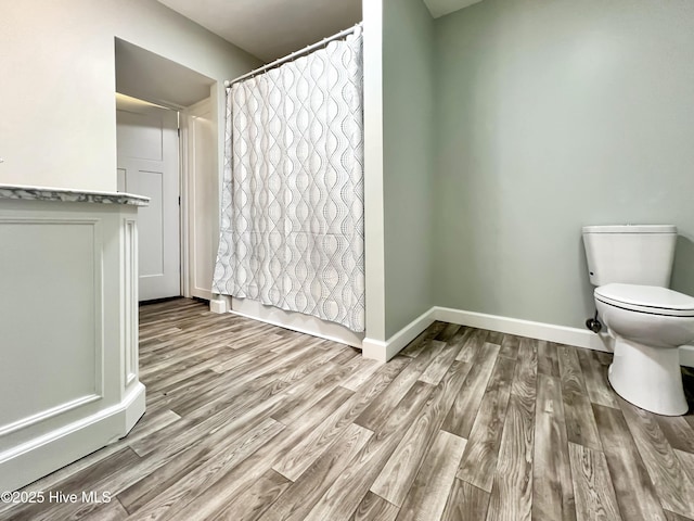 bathroom featuring hardwood / wood-style flooring and toilet