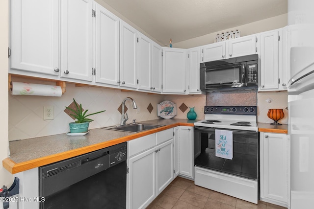 kitchen featuring sink, black appliances, light tile patterned floors, white cabinets, and backsplash