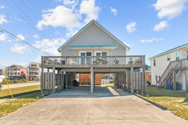 view of property featuring a carport, a front yard, and a deck