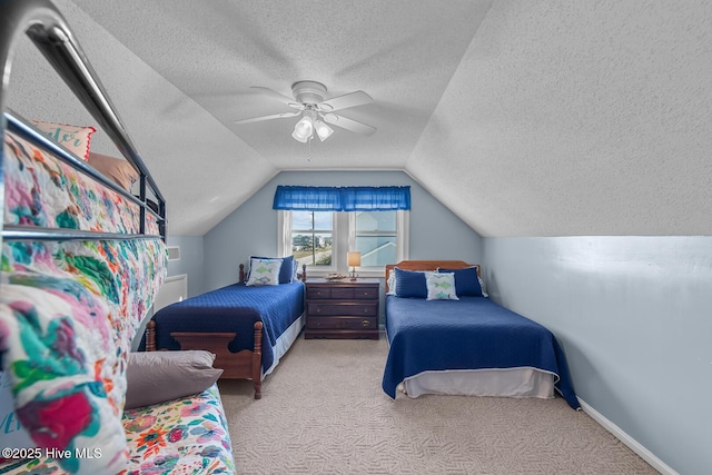 carpeted bedroom with ceiling fan, vaulted ceiling, and a textured ceiling