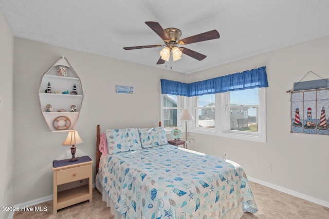 bedroom with light tile patterned floors, a textured ceiling, and ceiling fan