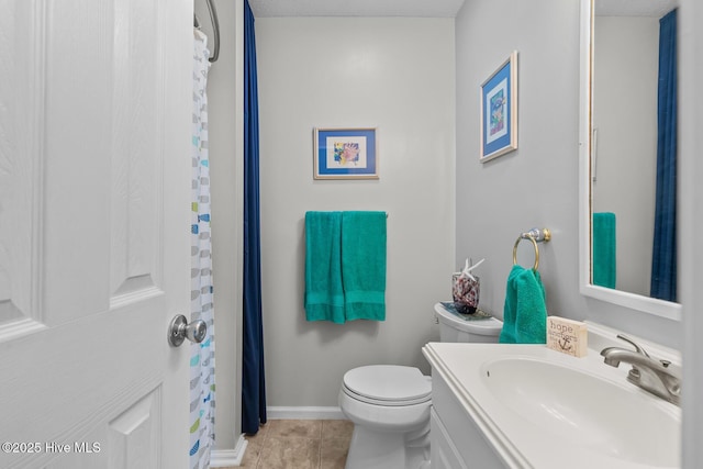 bathroom with tile patterned flooring, vanity, and toilet