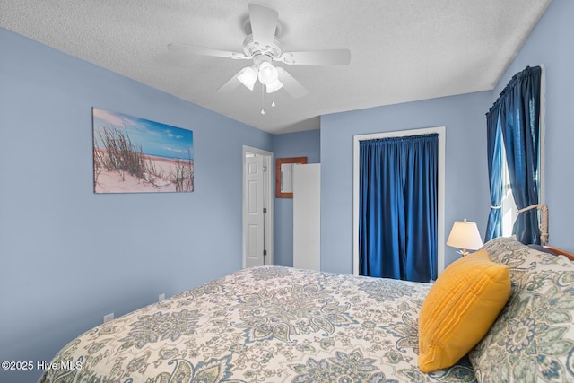 bedroom with ceiling fan and a textured ceiling