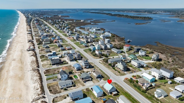 birds eye view of property with a water view and a beach view