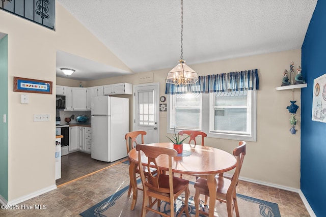 dining space featuring vaulted ceiling, a notable chandelier, and a textured ceiling