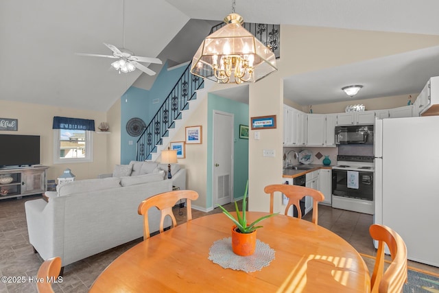 tiled dining room featuring sink, ceiling fan with notable chandelier, and high vaulted ceiling