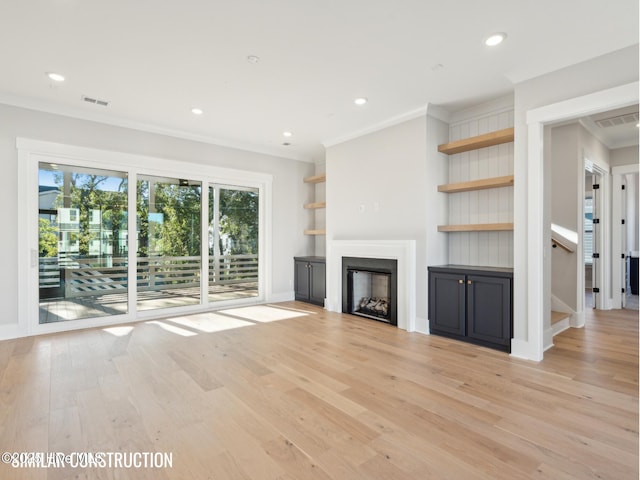 unfurnished living room featuring visible vents, ornamental molding, light wood-type flooring, a fireplace, and recessed lighting