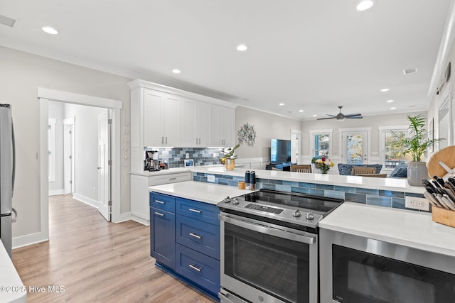 kitchen featuring light wood-style floors, white cabinetry, appliances with stainless steel finishes, and light countertops