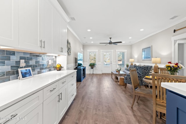 kitchen with ornamental molding, open floor plan, light countertops, and light wood-style flooring