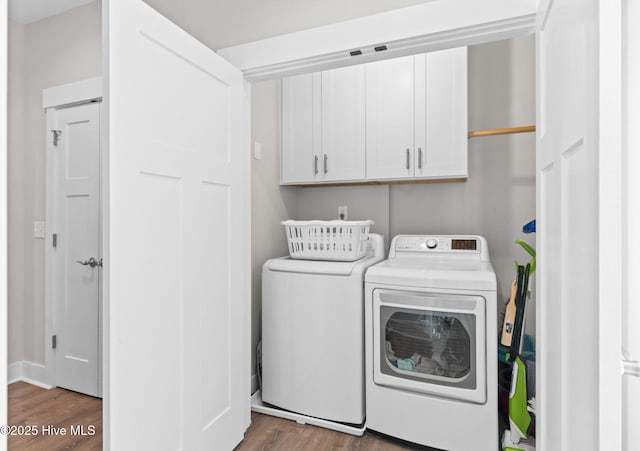 laundry area with cabinet space, washing machine and dryer, and wood finished floors