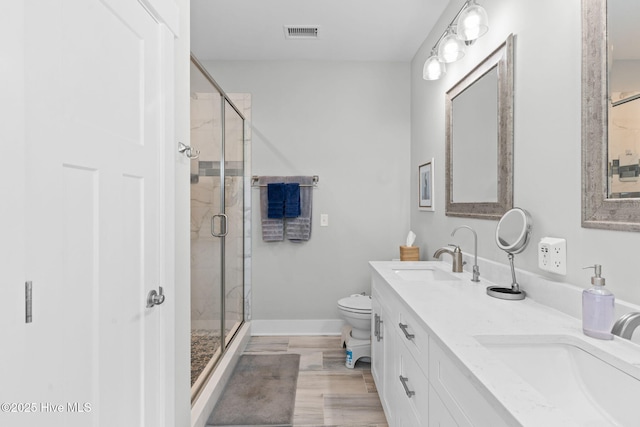 bathroom with a stall shower, visible vents, a sink, and baseboards