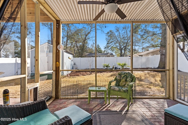 unfurnished sunroom with ceiling fan