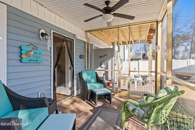 sunroom / solarium featuring a ceiling fan