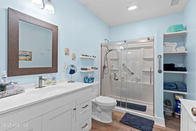 bathroom featuring a stall shower, wood finished floors, and vanity