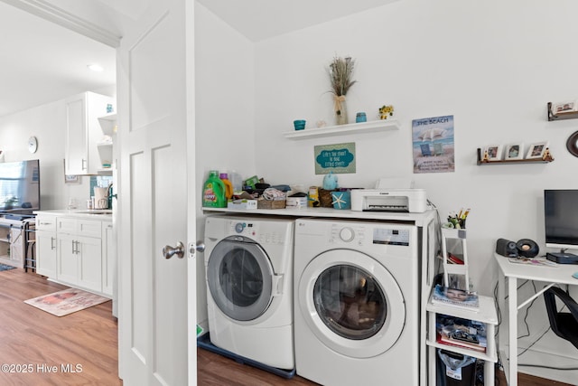 laundry area featuring a sink, laundry area, light wood-type flooring, and washing machine and dryer