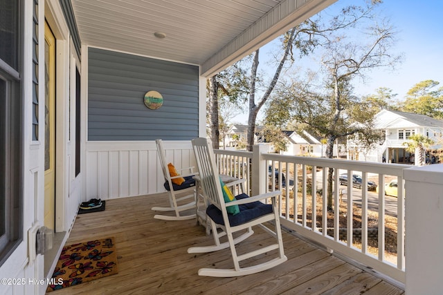 wooden deck with covered porch and a residential view