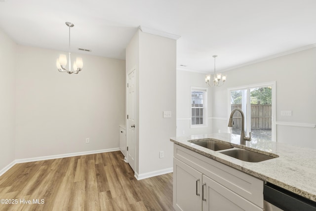 1010 Winterberry Cir, Leland, NC 28451 - kitchen with a chandelier, a sink, light wood finished floors, stainless steel dishwasher, and light stone countertops