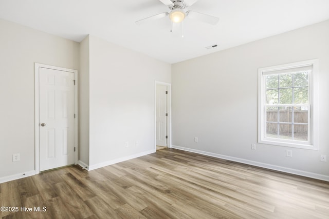 1010 Winterberry Cir, Leland, NC 28451 - unfurnished bedroom with wood finished floors, baseboards, and ceiling fan