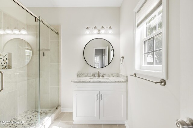 bathroom featuring vanity, baseboards, tile patterned flooring, and a shower stall