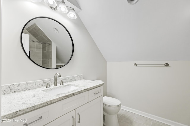 bathroom featuring vanity, toilet, and lofted ceiling