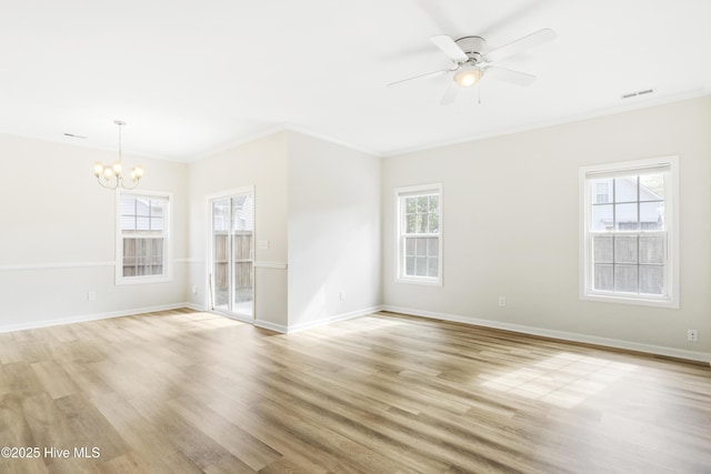 empty room with ornamental molding, ceiling fan with notable chandelier, light wood-type flooring, and visible vents