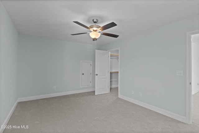 unfurnished bedroom featuring baseboards, ceiling fan, carpet, a spacious closet, and a closet