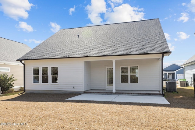 back of house featuring a patio, a shingled roof, a lawn, and central air condition unit