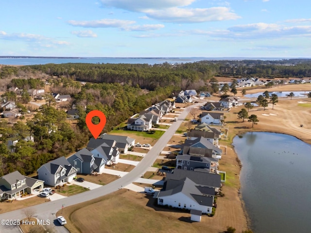 aerial view featuring a forest view, a water view, and a residential view