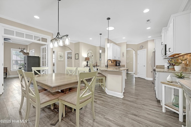 dining space featuring ornamental molding and hardwood / wood-style floors