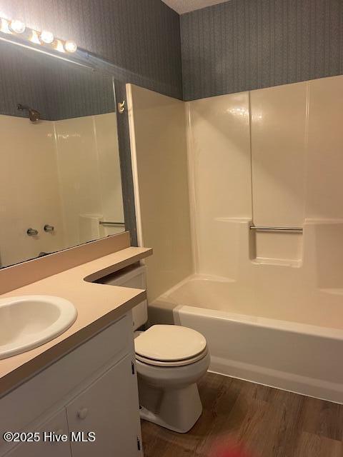 full bathroom featuring vanity, wood-type flooring, bathtub / shower combination, and toilet