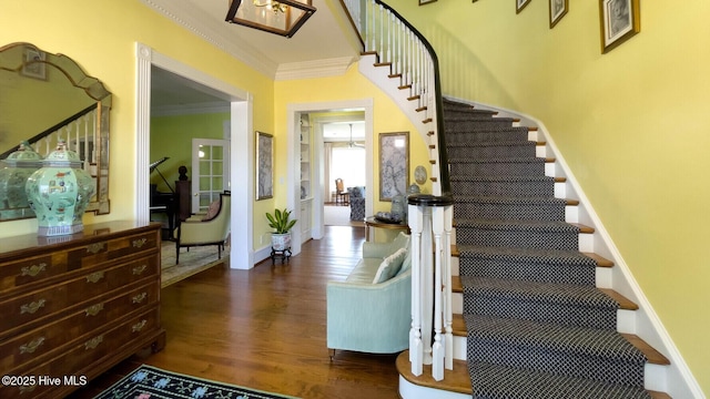 stairs featuring ornamental molding and wood-type flooring