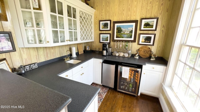 bar featuring wine cooler, sink, white cabinetry, fridge, and dark hardwood / wood-style floors