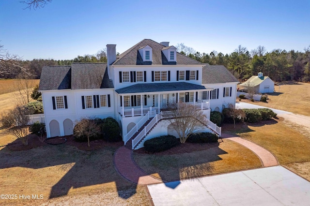 colonial home with a porch and a front lawn