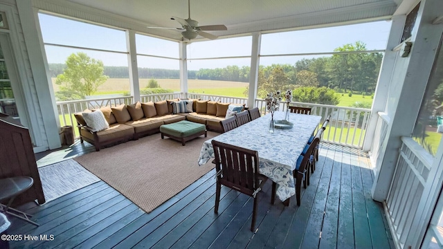 sunroom with a rural view and ceiling fan