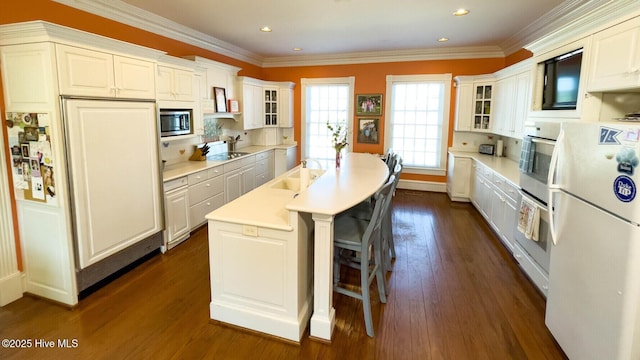 kitchen featuring crown molding, stainless steel appliances, dark hardwood / wood-style floors, and white cabinets