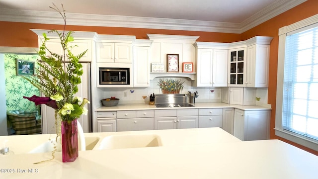 kitchen featuring stainless steel microwave, white cabinetry, gas cooktop, and decorative backsplash