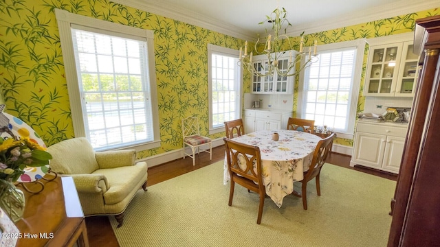 dining space featuring ornamental molding, a notable chandelier, and light wood-type flooring