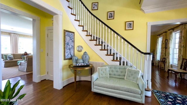 staircase with ornamental molding and hardwood / wood-style floors