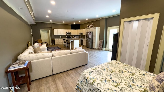 living room with crown molding and light hardwood / wood-style floors