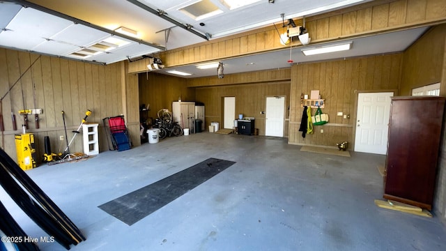 garage featuring a garage door opener and wooden walls