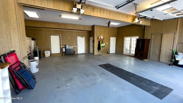 garage featuring a garage door opener and wooden walls