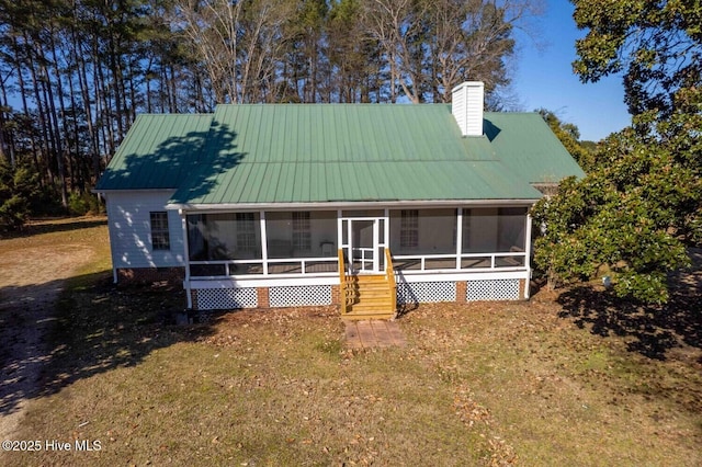 farmhouse with a front yard and a sunroom