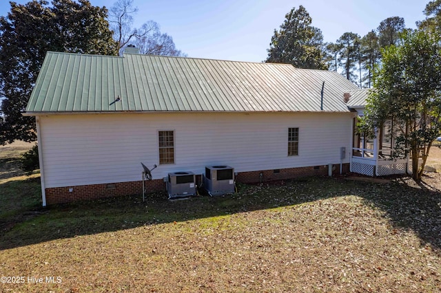 view of side of property featuring a lawn and central air condition unit