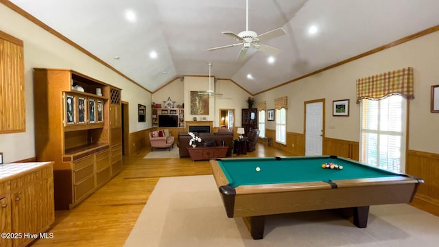 recreation room with crown molding, ceiling fan, vaulted ceiling, and light hardwood / wood-style flooring