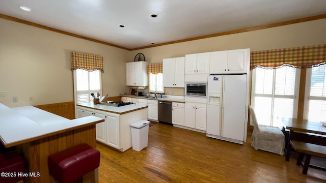 kitchen featuring sink, light hardwood / wood-style flooring, appliances with stainless steel finishes, a center island, and white cabinets