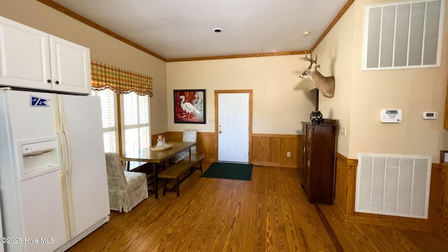 interior space with wood-type flooring, ornamental molding, and wood walls