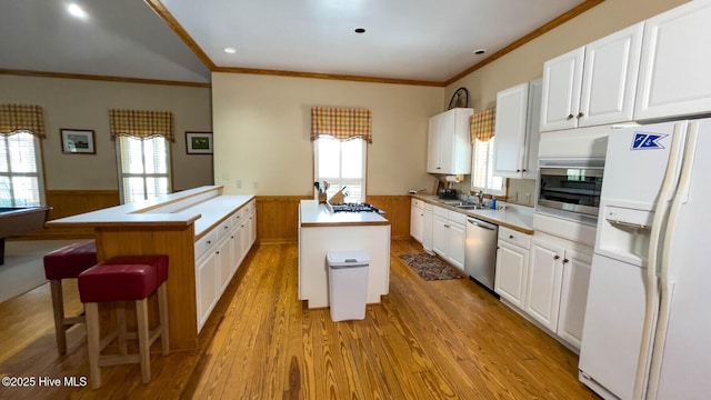 kitchen with white cabinetry, stainless steel appliances, kitchen peninsula, and a kitchen island