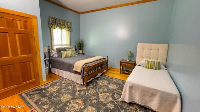 bedroom featuring wood-type flooring and ornamental molding