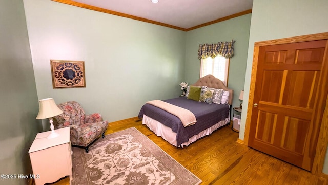 bedroom with ornamental molding and hardwood / wood-style floors