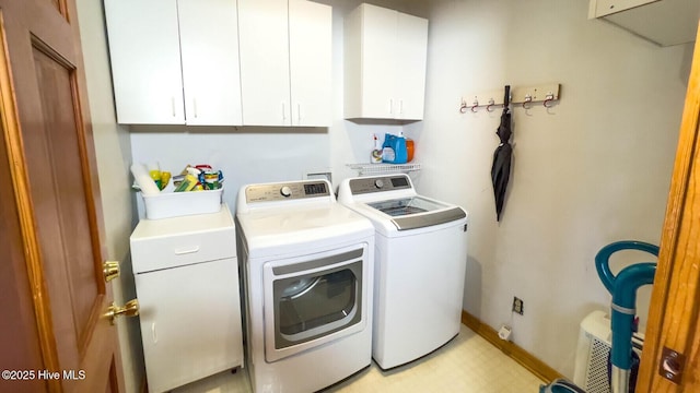 laundry room featuring cabinets and washer and clothes dryer